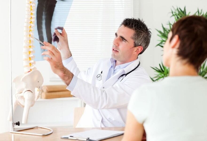 The doctor examines an x-ray to diagnose thoracic osteochondrosis.